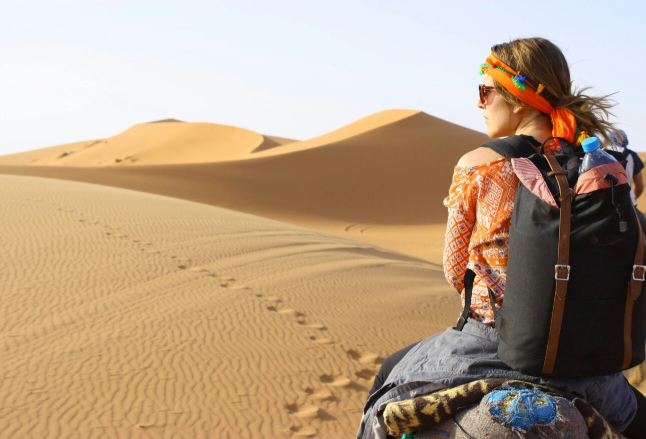 woman riding animal on dessert