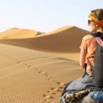 woman riding animal on dessert